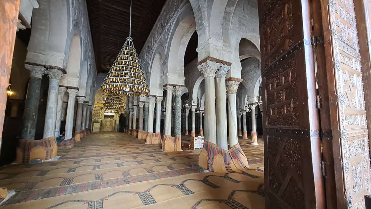 Ornate columns and grand chandelier inside the Great Mosque of Kairouan – a stunning example of early Islamic architecture and one of the top cultural places to visit in Tunisia.
