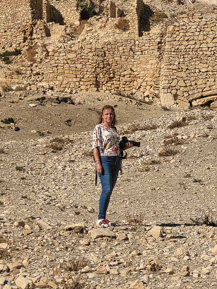 Maria Dol of Map and Camera exploring the stone ruins of Beni Zelten village in southern Tunisia – a lesser-known but culturally rich destination among unique places to visit in Tunisia.