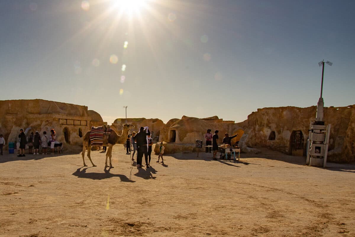 Visitors and camels at Mos Espa, a preserved Star Wars movie set in the Sahara Desert of Tunisia – a surreal and cinematic stop among the top desert attractions in Tunisia.