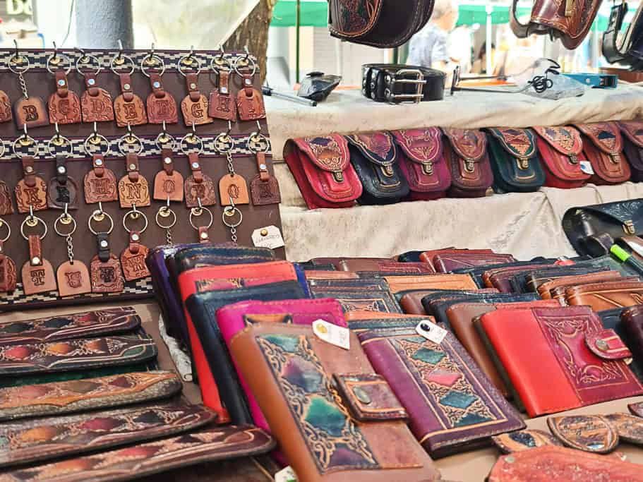 Handcrafted leather wallets, keychains, and pouches with intricate designs, showcasing traditional Argentine craftsmanship, on display at a Buenos Aires artisan market. A perfect souvenir option for travelers in search of authentic Argentine leather goods.