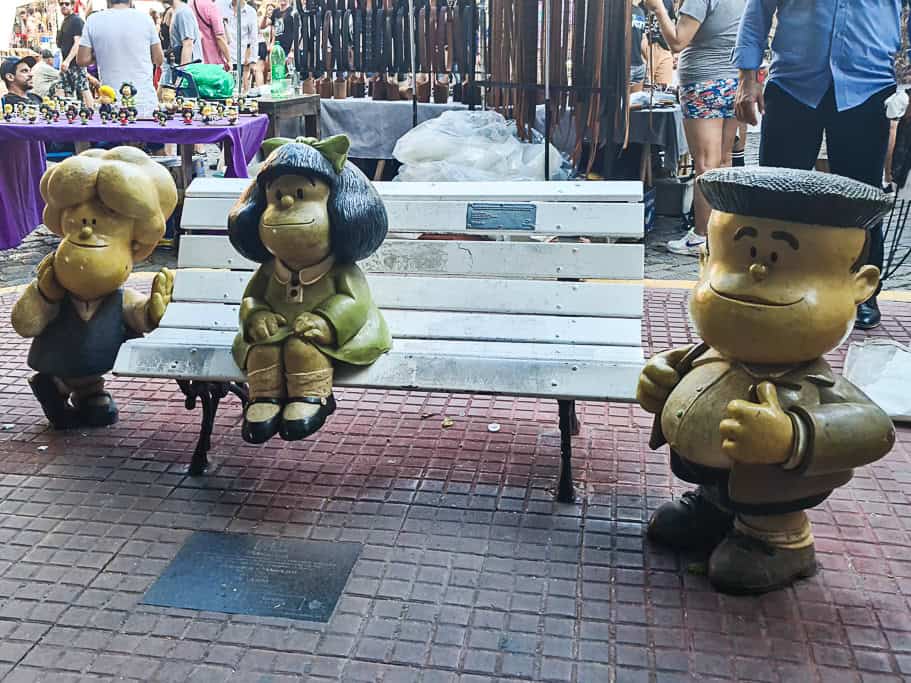 Life-sized statues of Mafalda and her friends on a bench at San Telmo market in Buenos Aires. A charming spot for fans of the iconic Argentine cartoon character and a great way to explore Mafalda-themed souvenirs in Argentina.
