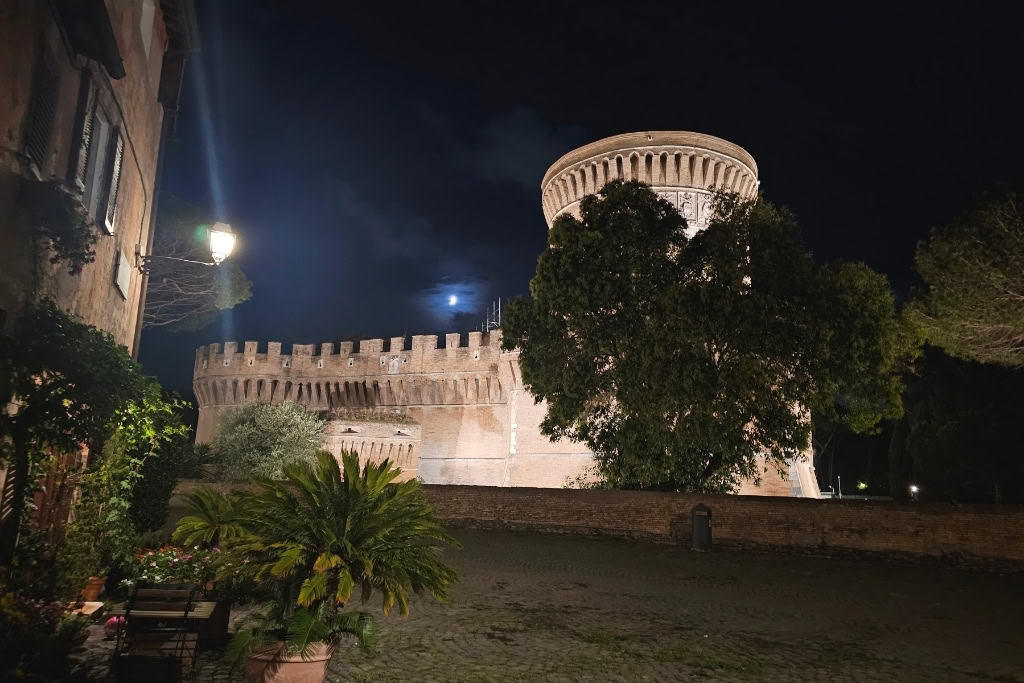 Julius II Castle illuminated at night in Ostia Antica, a unique spot comparing Ostia Antica vs Pompeii.