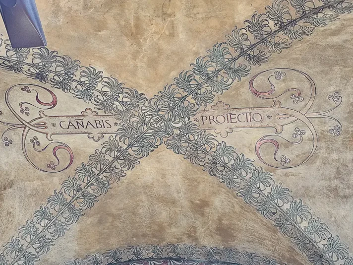Close-up of the “Canabis Protectio” inscription painted above a Bologna portico — one of the city's most whispered-about artistic secrets.