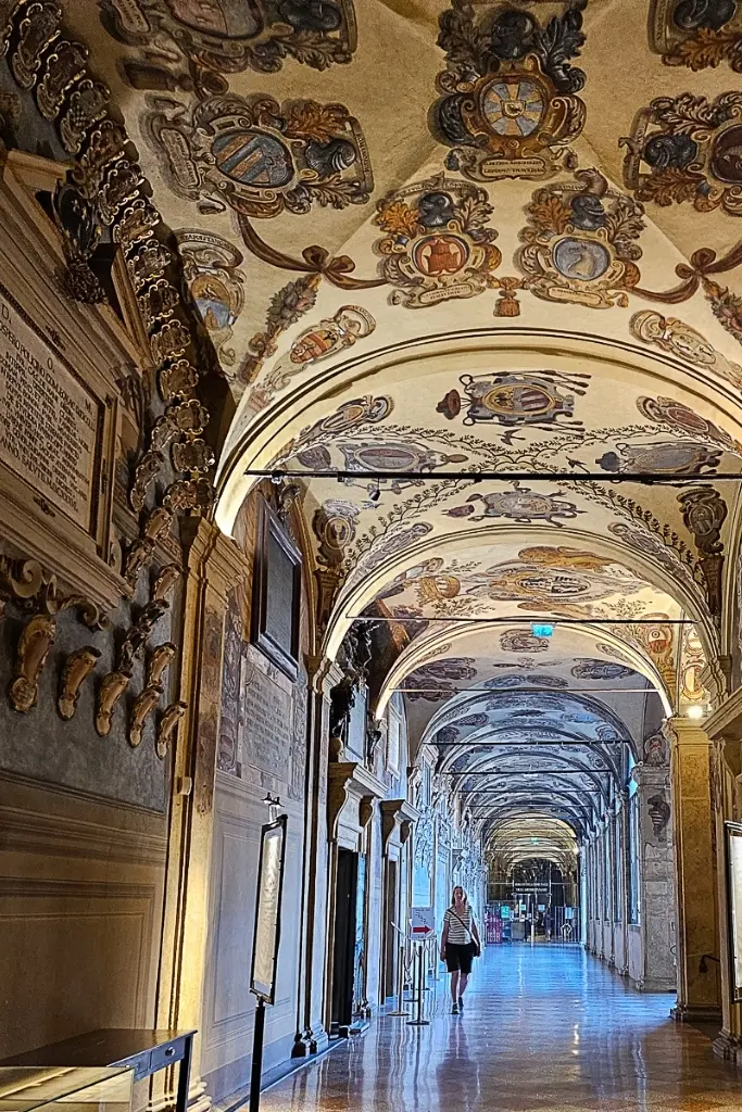 Ornate vaulted corridor of the Archiginnasio Palace in Bologna, Italy, featuring historical coat-of-arms frescoes—one of the best indoor photography spots in Bologna for capturing Renaissance details.