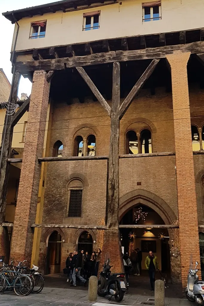 Historic wooden portico of Casa Isolani in Bologna, supported by 13th-century beams—one of the city’s best-preserved medieval structures and a top location for architecture photography.