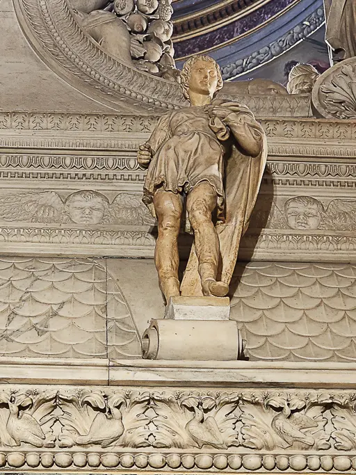 Statue of a youthful David sculpted by Michelangelo as part of the Arca di San Domenico in Bologna. This early Renaissance work is a prototype for the later, more famous David statue in Florence and showcases Michelangelo’s emerging sculptural mastery.