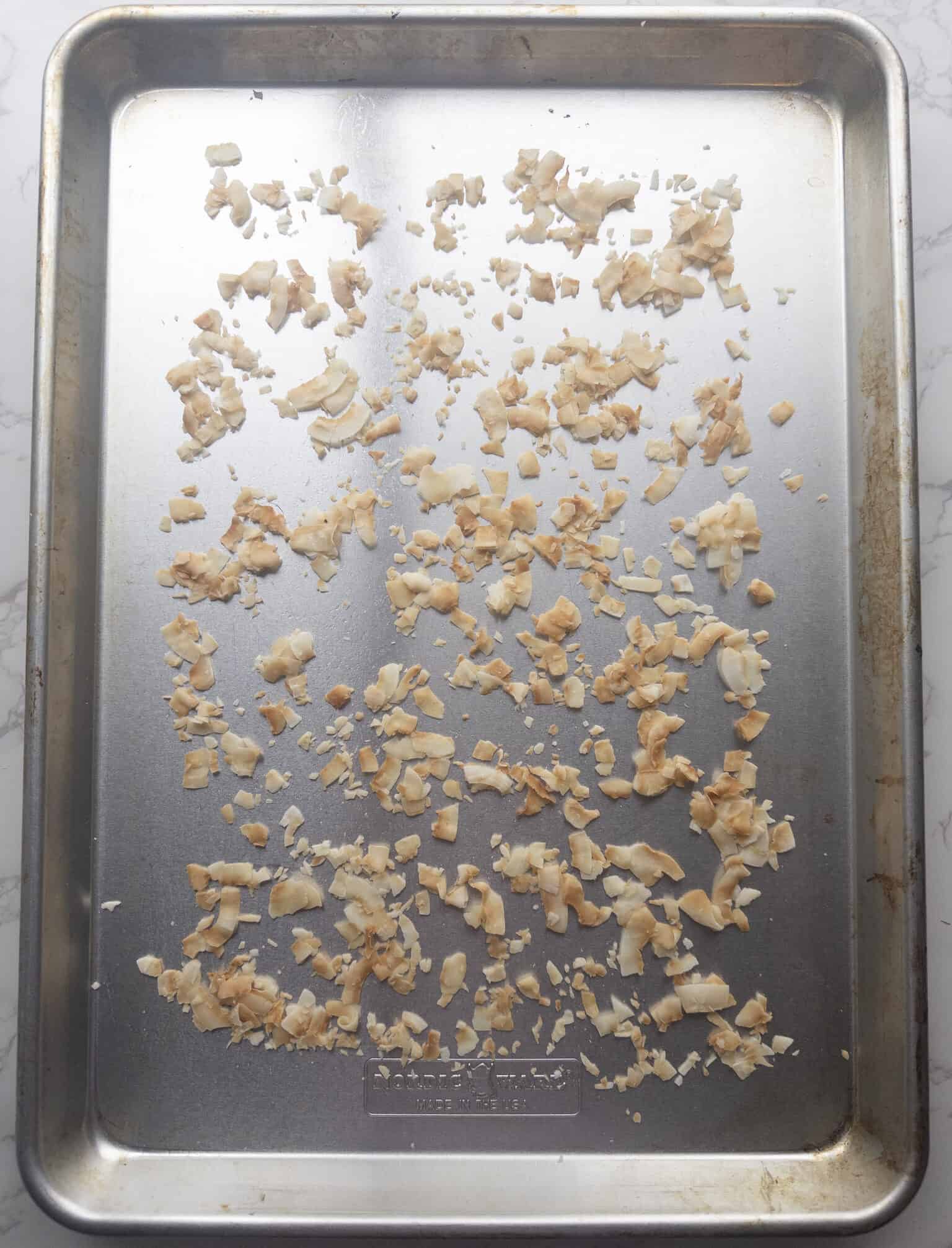 Toasted coconut flakes on baking sheet