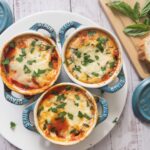 baked eggs in tomato sauce in mini cocotte dishes