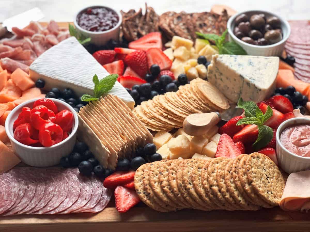 Charcuterie board with meats, cheese, crackers and fruit.