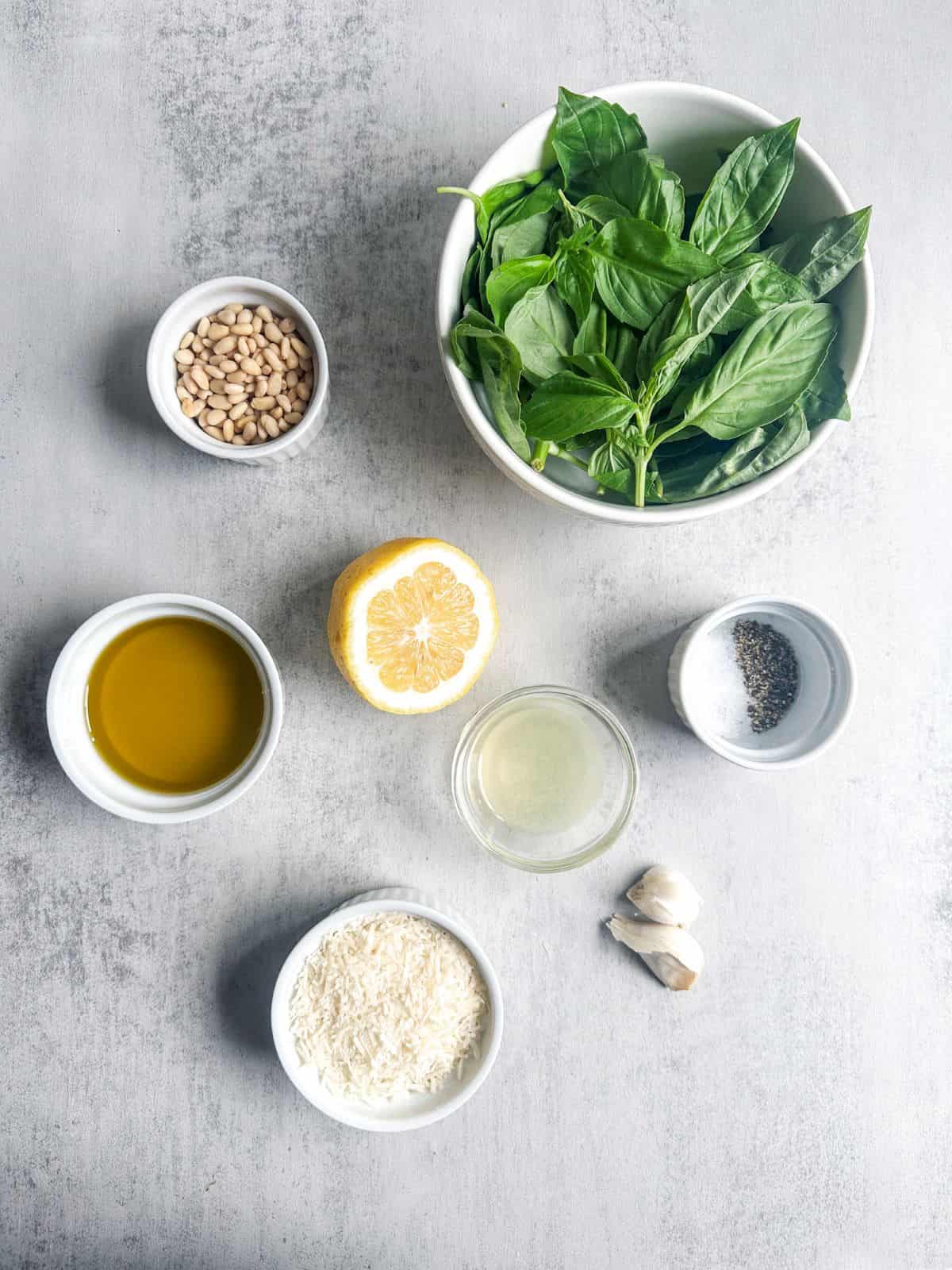 Fresh basil, pine nuts, garlic, olive oil, parmesan cheese for making pesto.