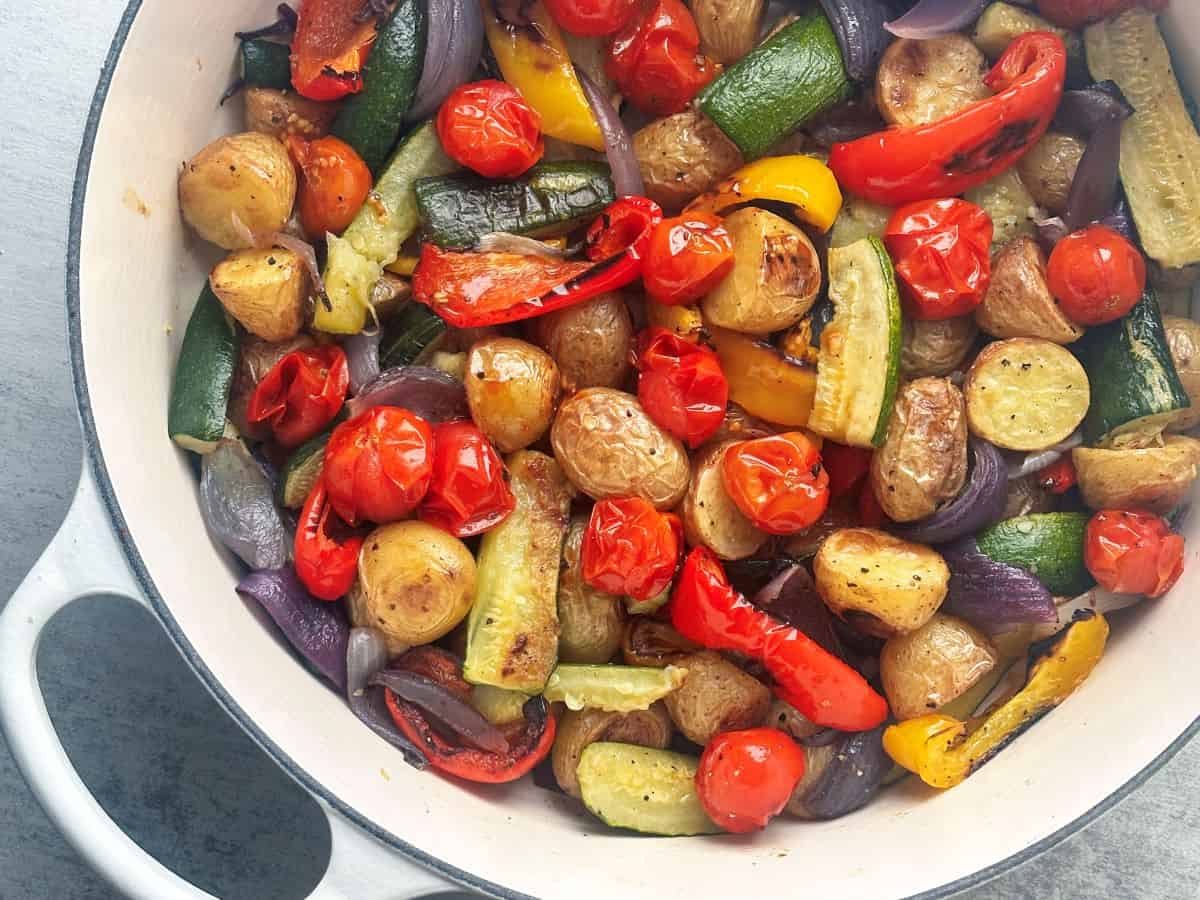 Italian-style roasted vegetables in large white pan.