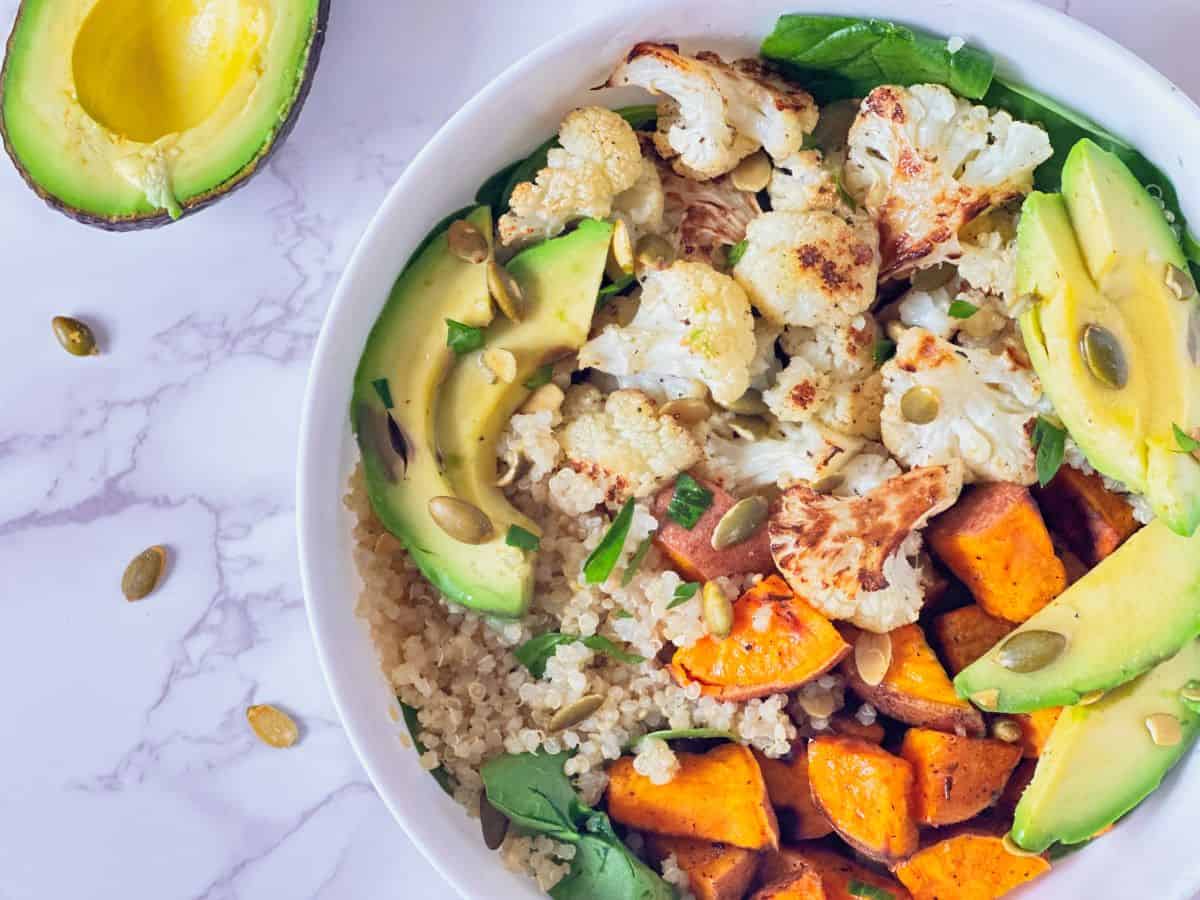 Roasted veggie grain bowl with sweet potato, cauliflower, and avocado.