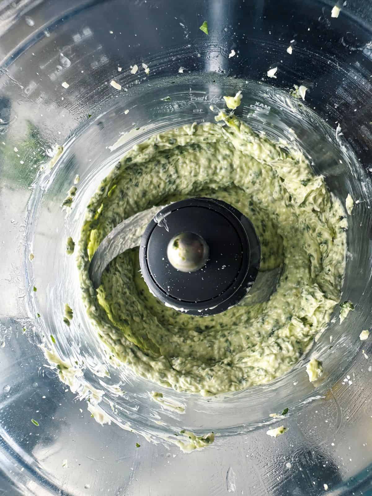 Whipped pesto butter in a food processor bowl.