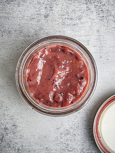 Cranberry honey mustard sauce in a open mason jar with lid on the side.