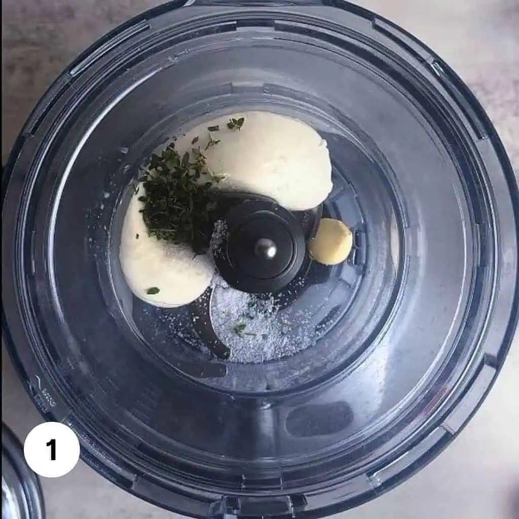 Burrata cheese, garlic, fresh thyme and salt in the bowl of a food processor.