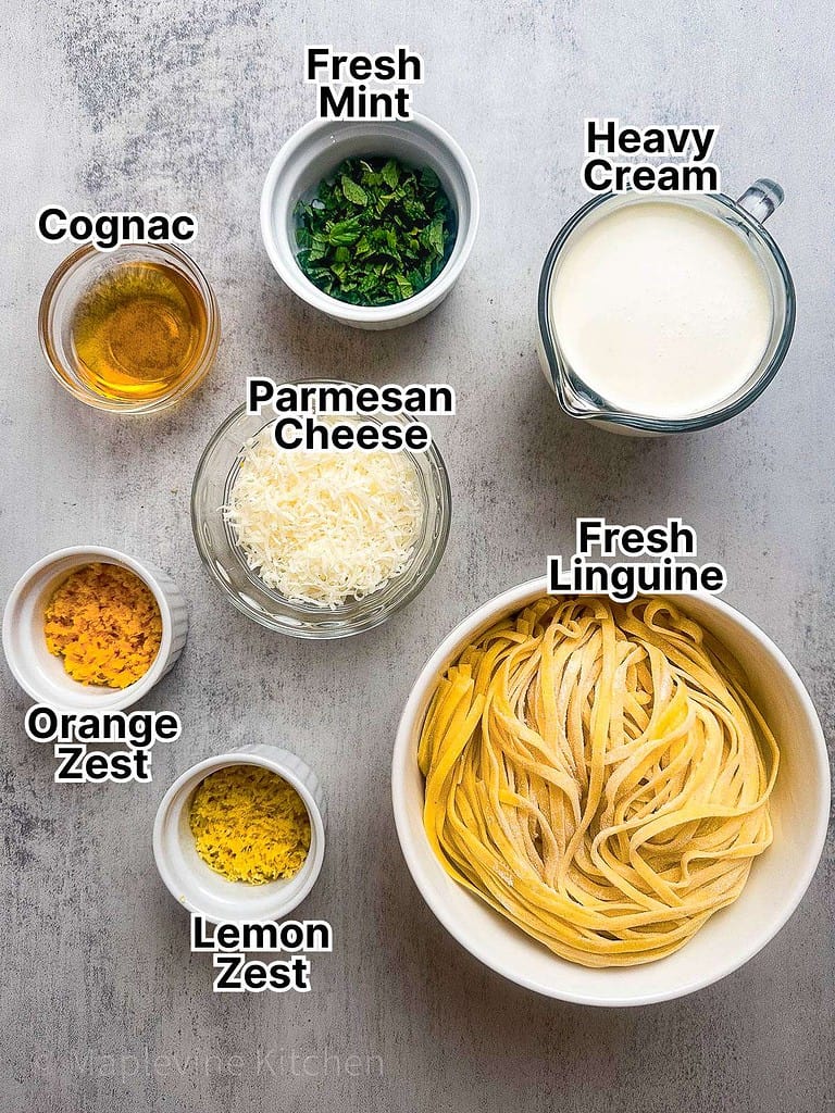 Ingredients for pasta magnifico laid out in small white bowls on a gray countertop.