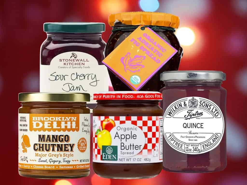 Jars of various jams and spreads on a red background.