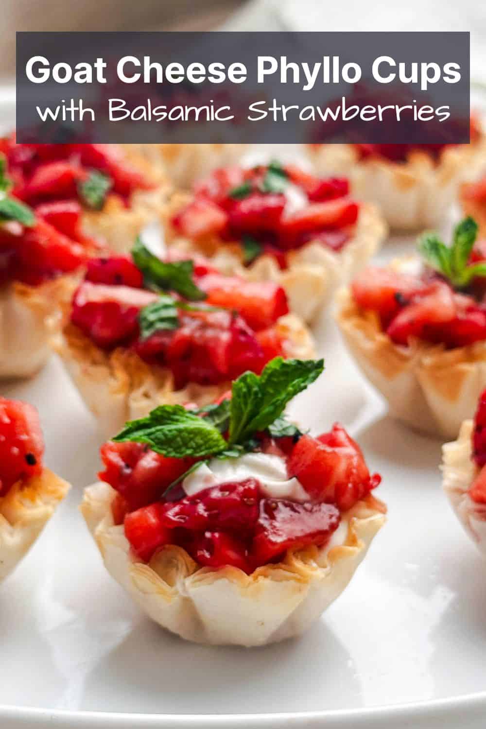 Goat cheese phyllo cups with balsamic strawberries on a white plate with the title of the recipe overlaid on top.