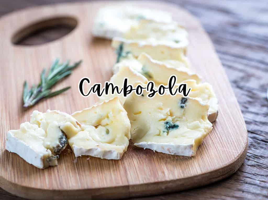 Slices of Cambozola cheese on a wooden board with rosemary sprigs.