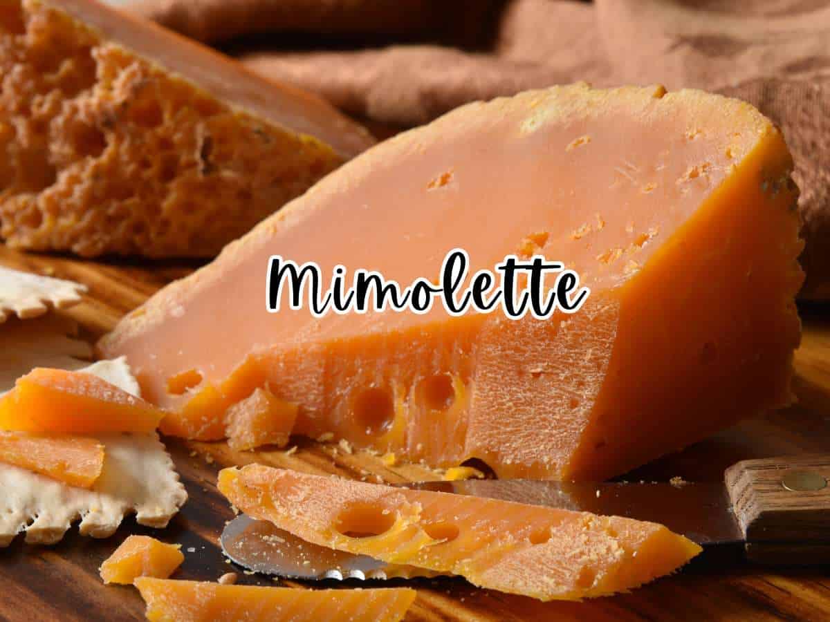 Wedges of Mimolette cheese with a cheese knife on a wooden board.
