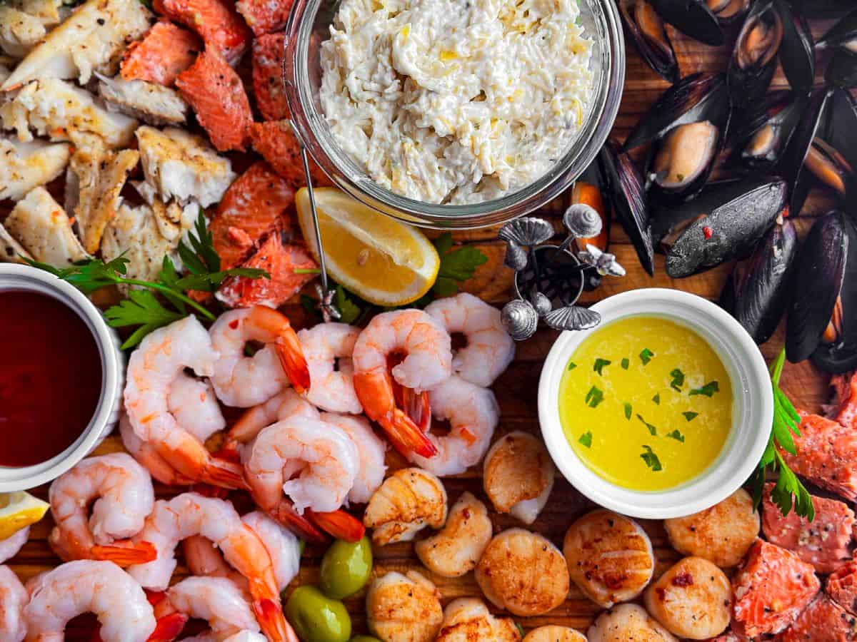 Prawns, scallops, halibut, salmon, and mussels on a charcuterie board.