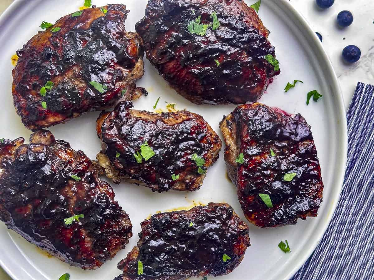 Blueberry barbecue chicken on a white plate.