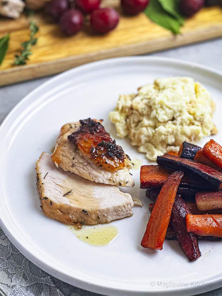 Maple bourbon glazed turkey breast slices on a white plate.