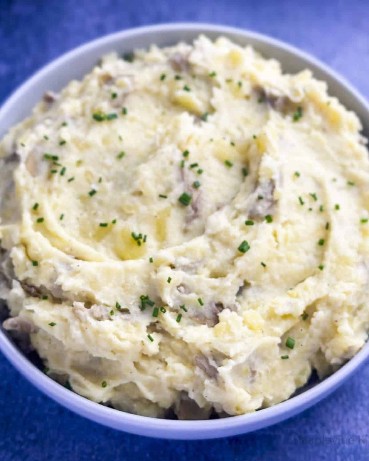 Yukon gold mashed potatoes in a bowl with chives for garnish.