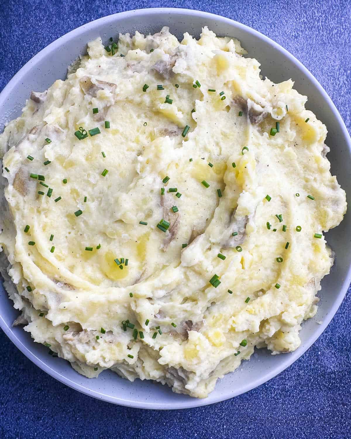 Overhead shot of Yukon Gold mashed potatoes in a bowl with chives.