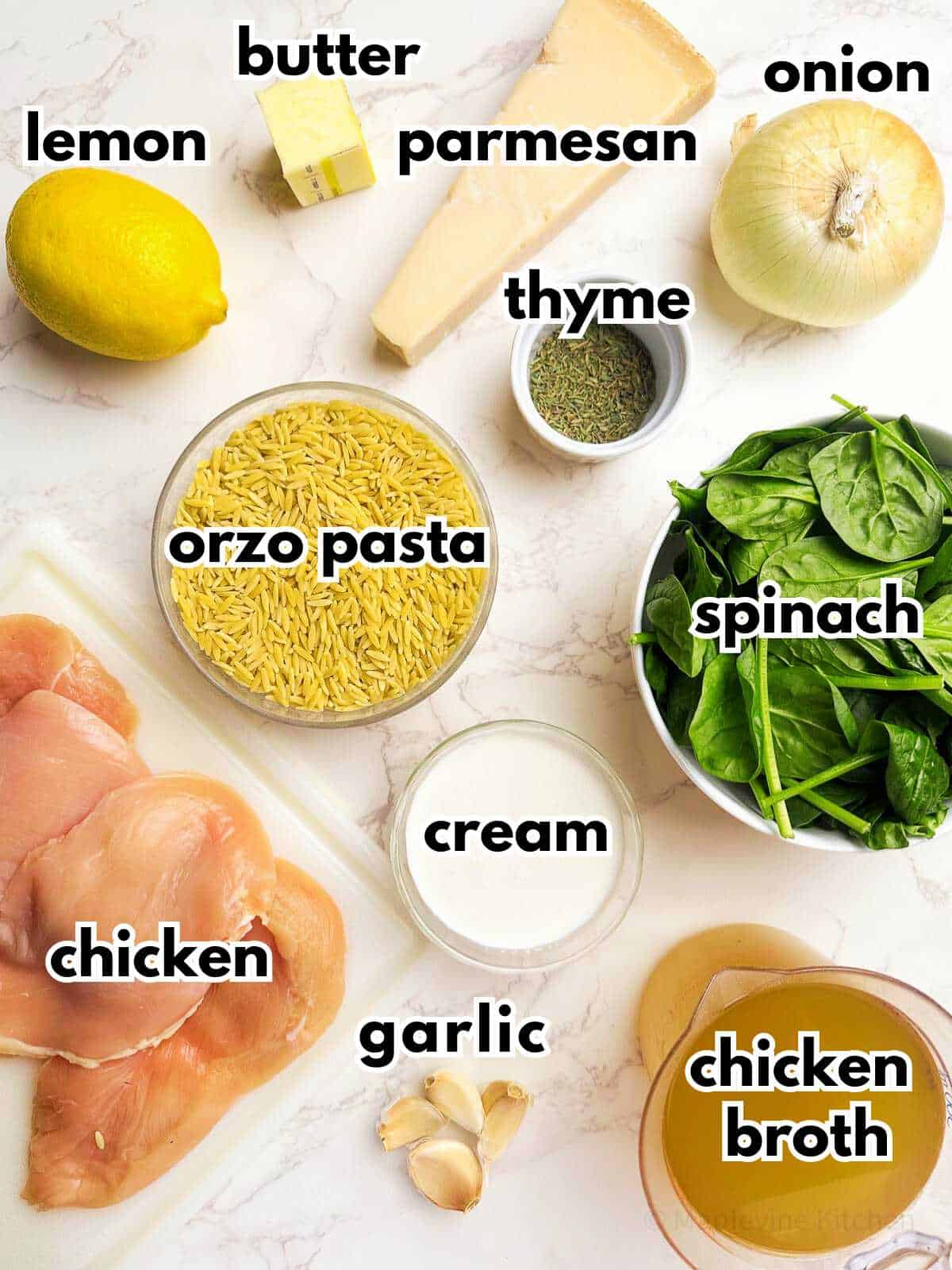 Ingredients for creamy lemon chicken orzo pasta on a marble countertop.