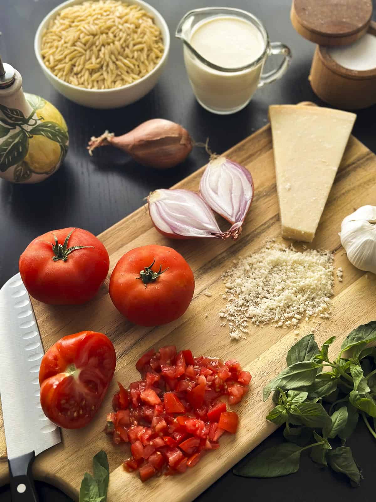 Ingredients for creamy tomato orzo pasta on a cutting board.
