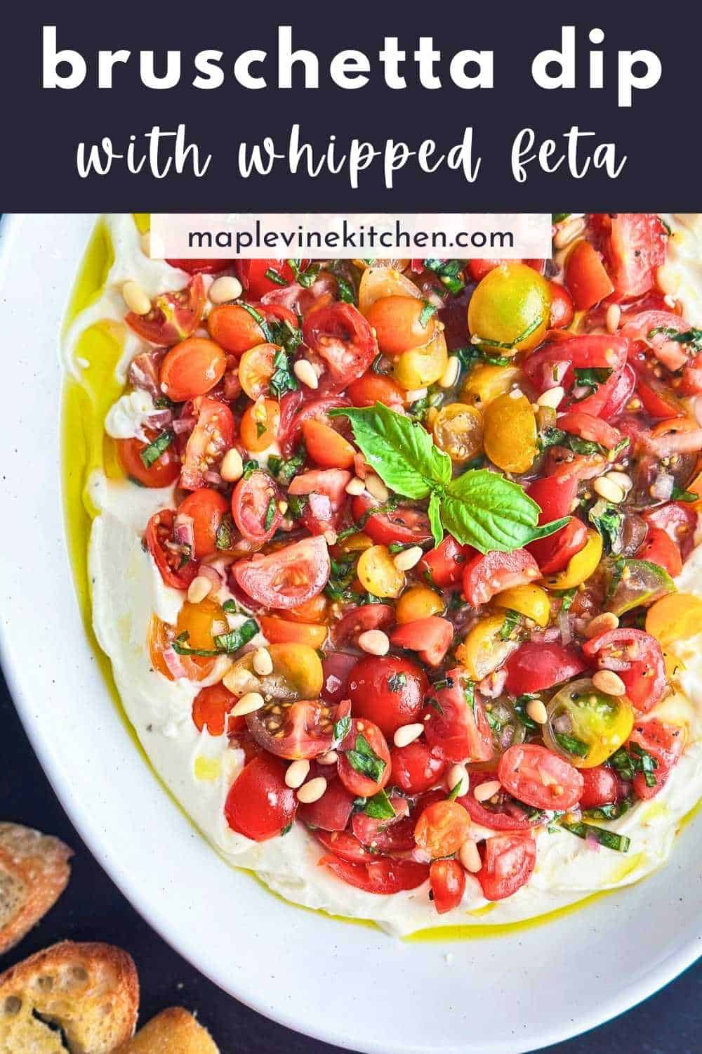 Fresh bruschetta dip with whipped feta and colorful cherry tomatoes on a white plate.