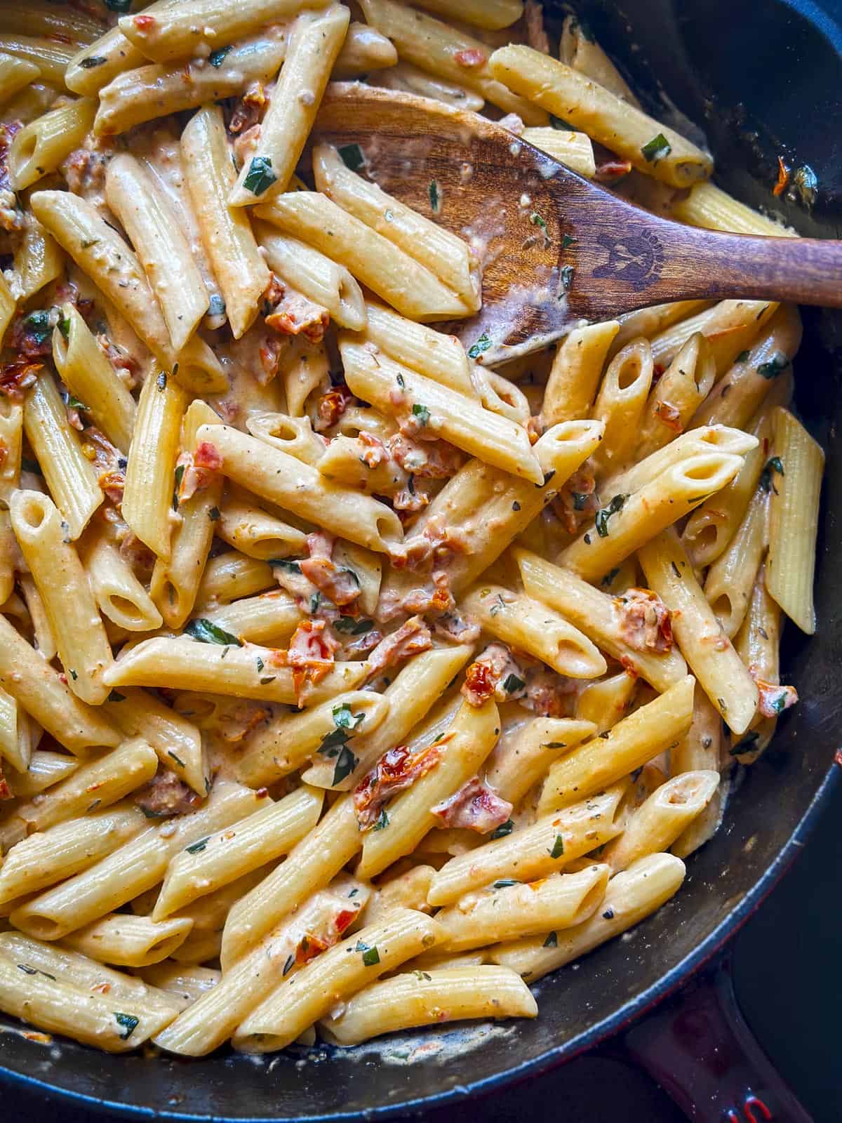 Penne pasta with creamy sun dried tomato sauce in a cast iron skillet.
