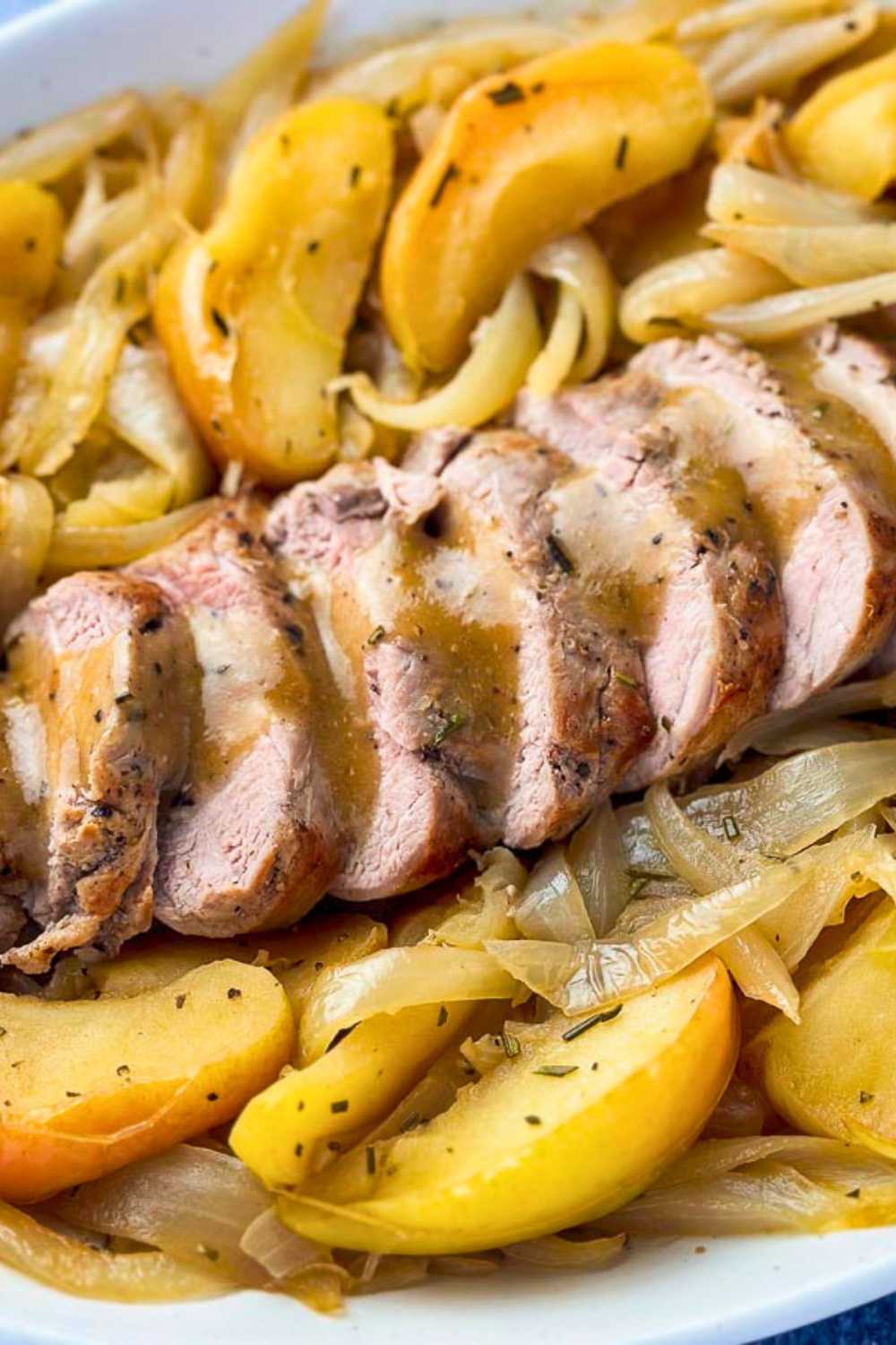 Sliced pork tenderloin on a bed of apples and onions with cider gravy drizzled on top.
