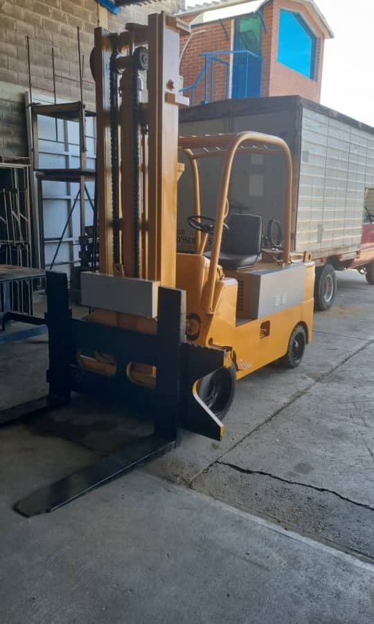 1. Montacarga eléctrico compacto de uso industrial, ideal para manejo de cargas en espacios reducidos y almacenes.