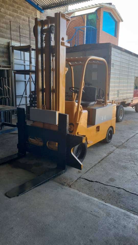 1. Montacarga eléctrico compacto de uso industrial, ideal para manejo de cargas en espacios reducidos y almacenes.