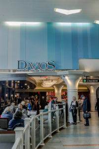 People dining and waiting at Davio's Northern Italian Steakhouse in an airport terminal.