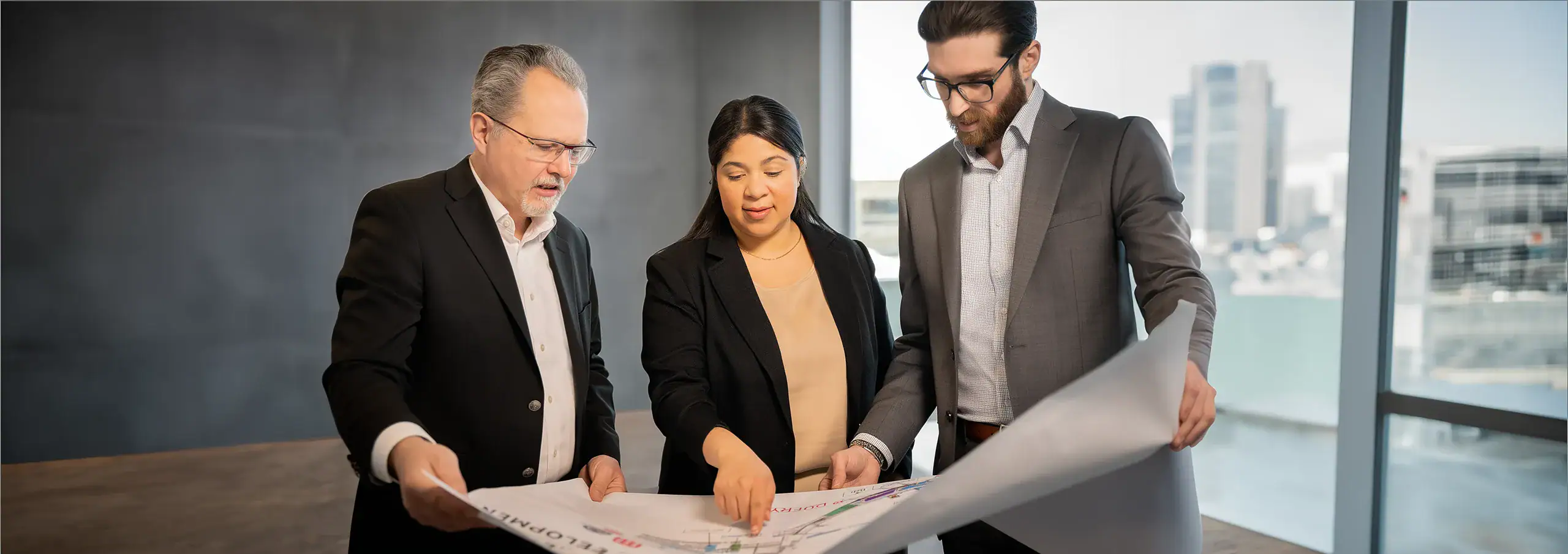 Team of three discussing leasing plans for Boston Logan International Airport
