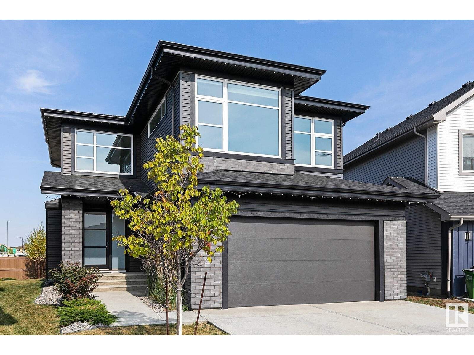 Modern black two-story house with large windows and a two-car garage in Edmonton.