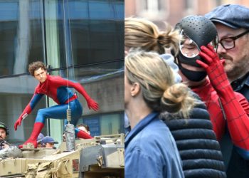 A new set photo from Spider-Man: Brand New Day shows Tom Holland in his Spider-Man suit wearing a black protective face mask, likely used between takes or before putting on the actual mask.