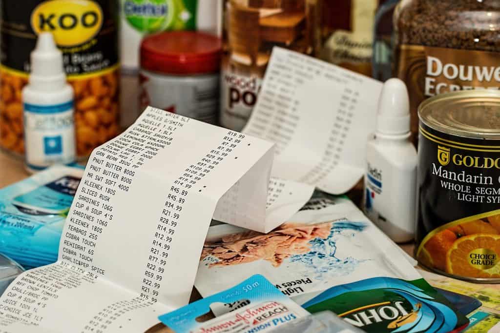 A rolling receipt among various household items, including food containers and personal care products, highlighting convenient meal planning and grocery shopping essentials.