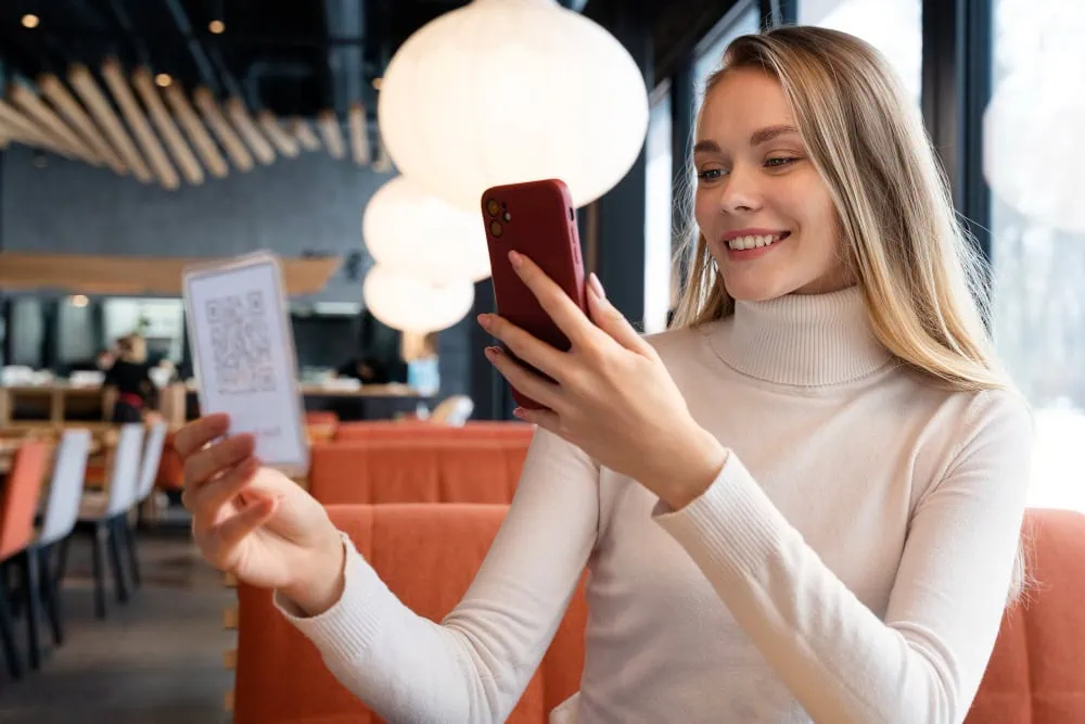 Ospite consulta la guida digitale per ospiti su smartphone in struttura ricettiva
