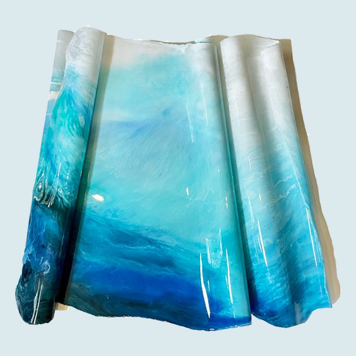 A blue and white piece of art on a white surface.