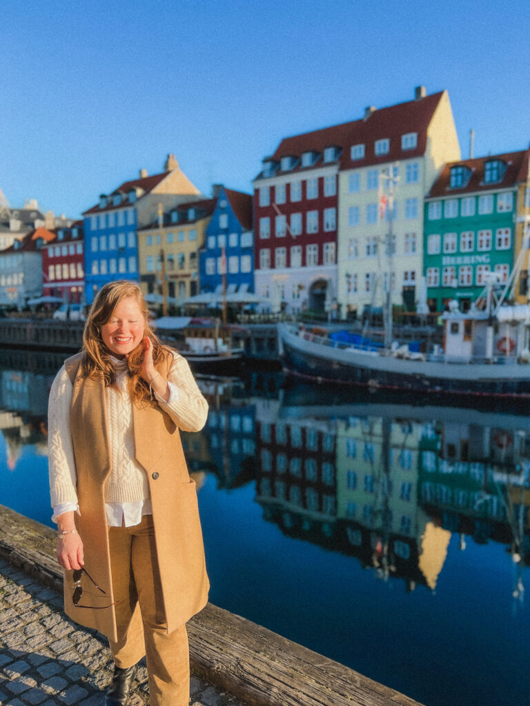 When planning your Copenhagen itinerary you have to see Nyhavn at sunrise, the light is stunning! This oceanfront town has the most beautiful harbor called Nyhavn which is a 17th century waterfront canal and entertainment district. You can see 17th and 18th century colorful townhouses in white, cream, yellow, orange, gray, and blue. All of them have similar square, symmetrical windows, and most with orange roofs. You'll find wooden and historical boats bobbing in the small harbor, and restaurant seating sprawling across the waterfront sidewalk.