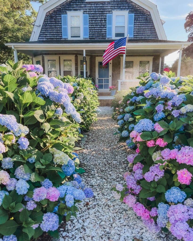 This classic Cape Cod house adorned with hydrangeas and an American flag out front is a classic scene in New England in the summer and one you'll find along your New England road trip.