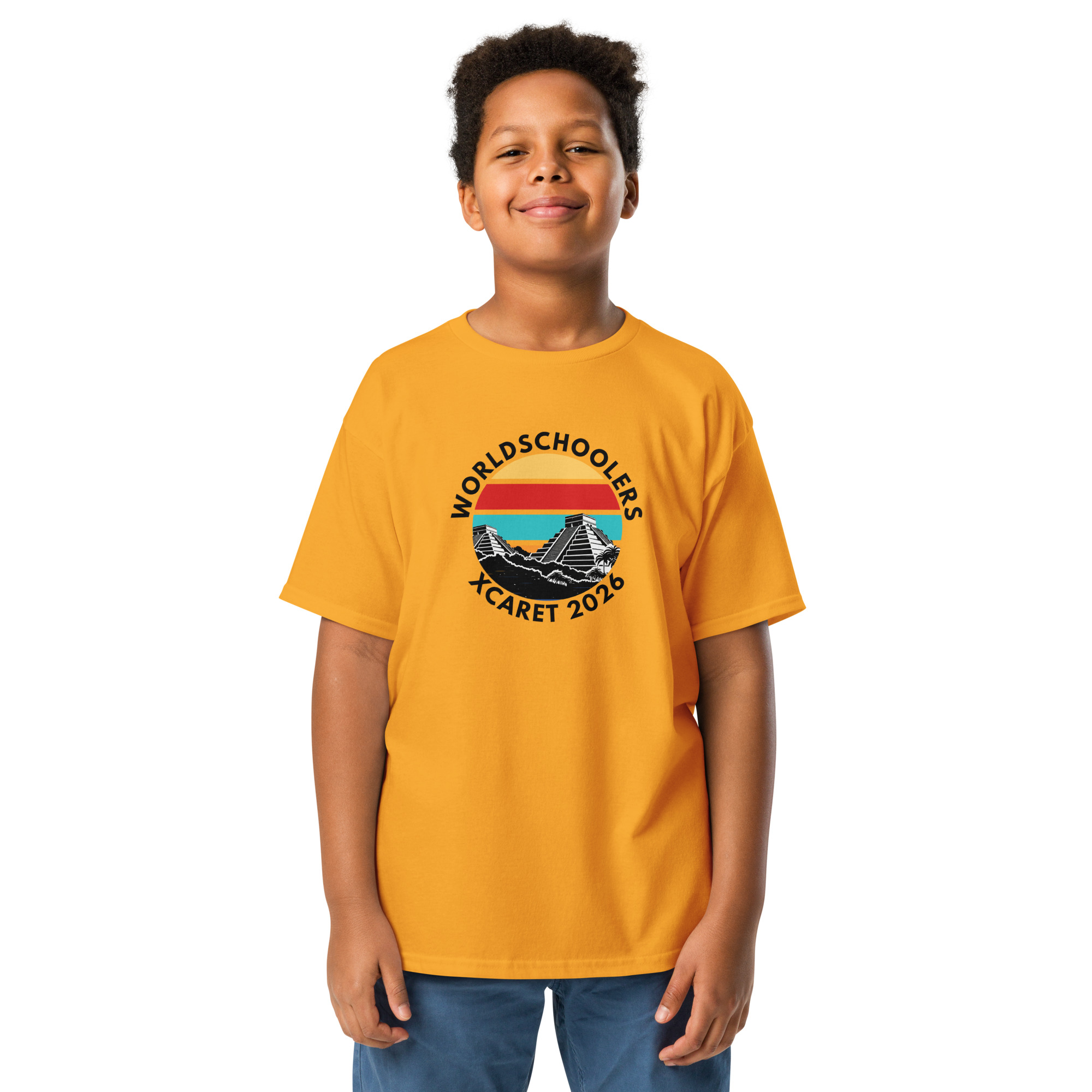 Young boy wearing a bright yellow Xcaret 2026 youth graphic tee with a mountain and sunset design, perfect for travel and adventure enthusiasts.