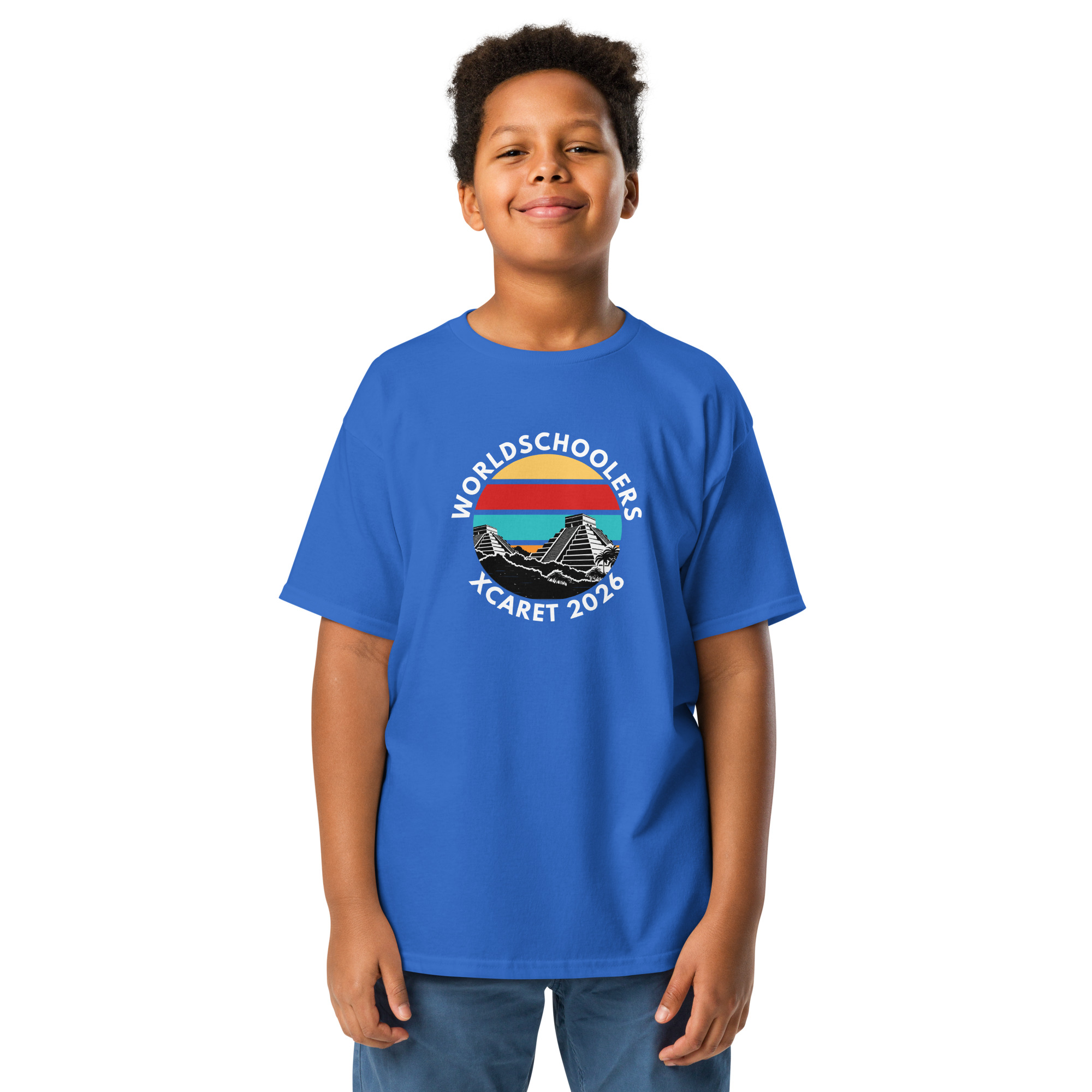 Child wearing a blue Xcaret 2026 youth classic graphic tee with mountain and sunset design, perfect for travel and adventure-themed fashion.