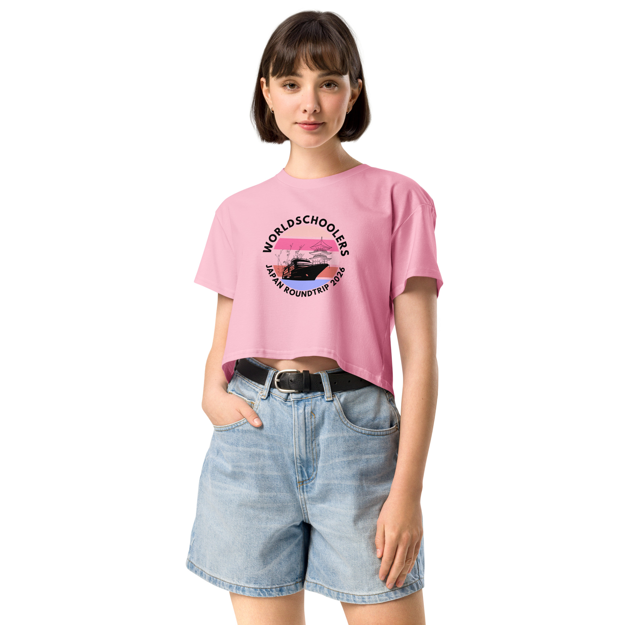 Woman wearing a pink crop top with "World Schoolers Japan Roundtrip 2026" logo, promoting travel and adventure for women.