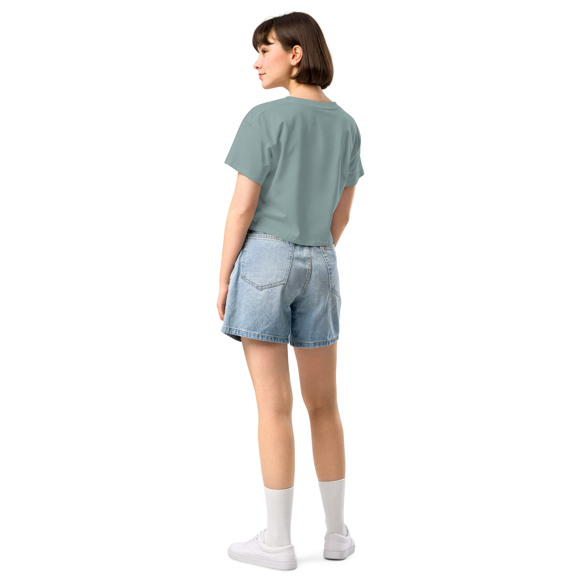 Casual women's crop top in soft teal paired with denim shorts, perfect for summer travel and casual outings.