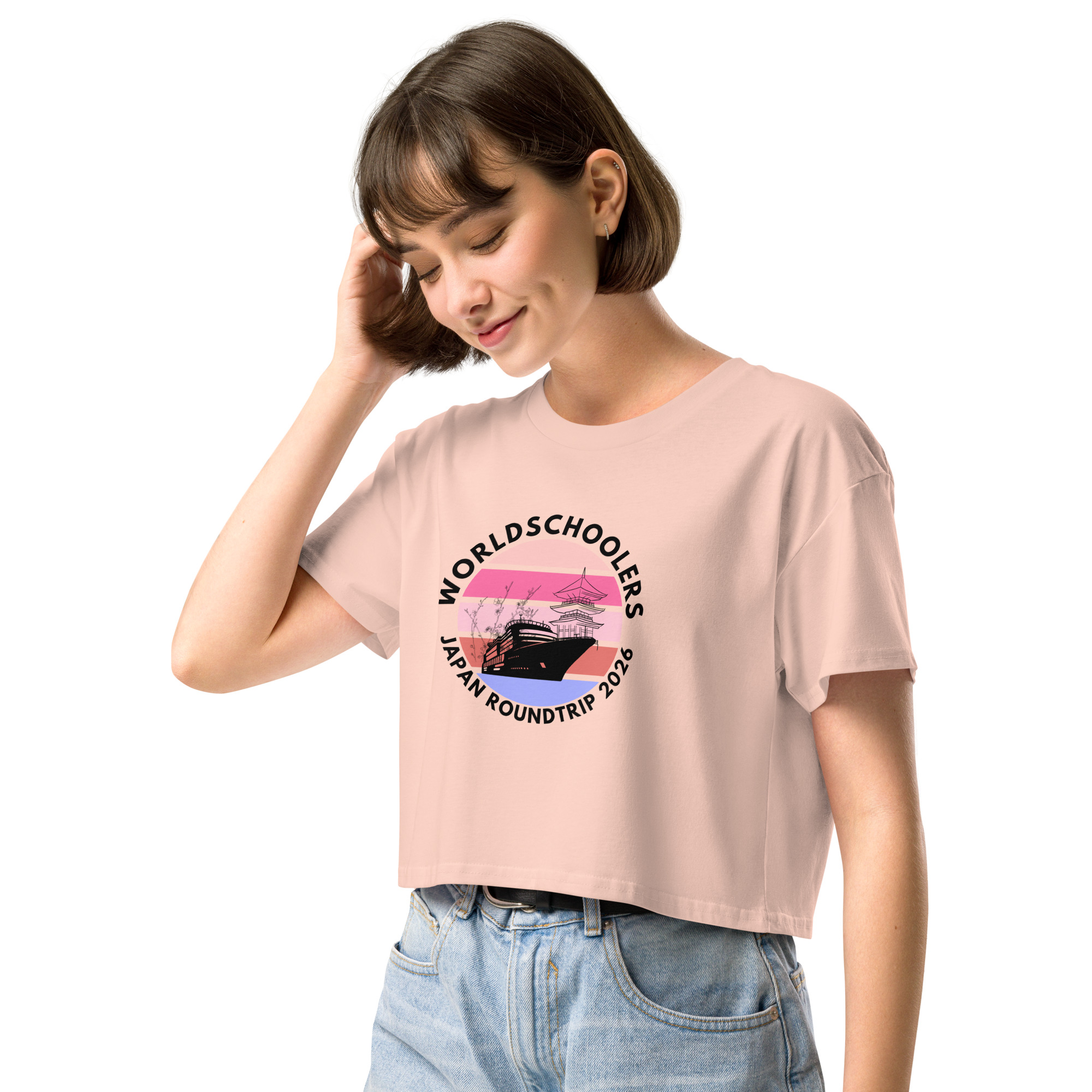 Young woman wearing a pink Japan Roundtrip 2026 crop top with a graphic design of a traditional Japanese boat and cherry blossoms, perfect for travel and casual fashion.